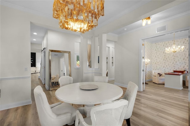 dining space with crown molding, an inviting chandelier, and light hardwood / wood-style floors