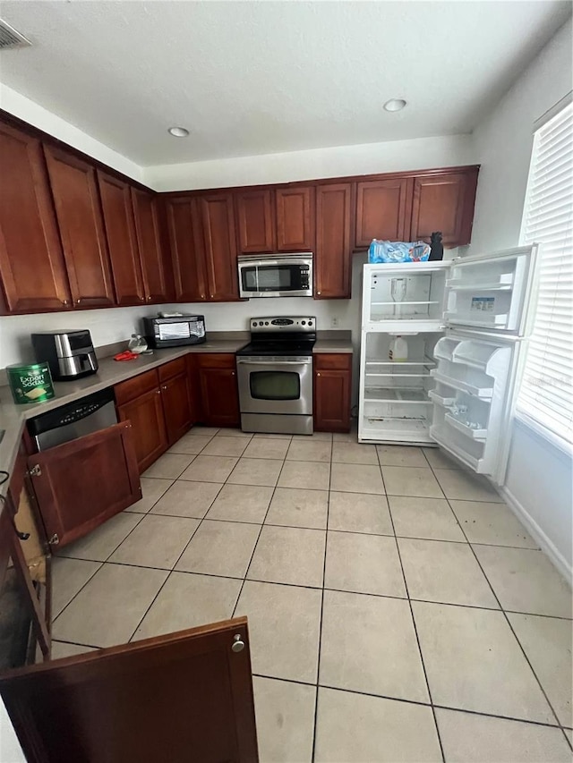 kitchen with light tile patterned flooring and appliances with stainless steel finishes