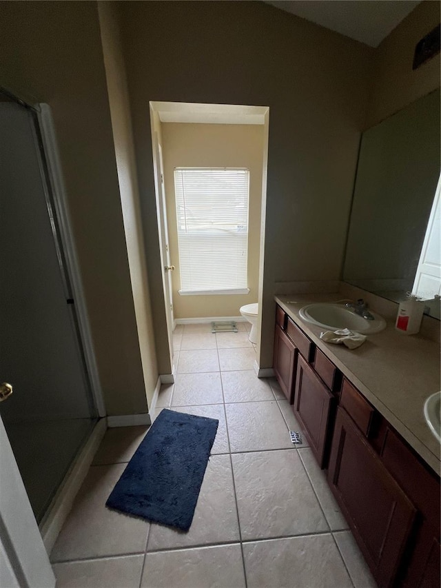 bathroom with tile patterned flooring, vanity, an enclosed shower, and toilet