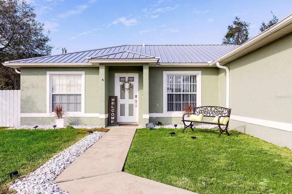 view of exterior entry with a lawn