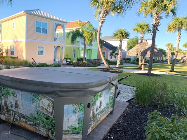 exterior space featuring a front yard and a hot tub