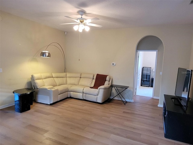 living room with wood-type flooring and ceiling fan