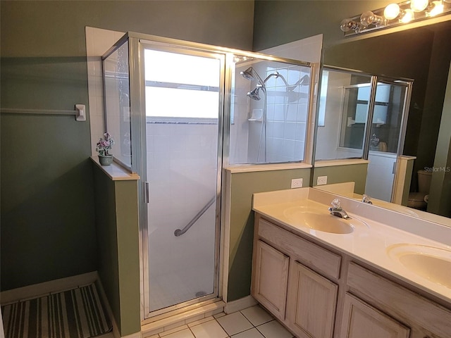 bathroom featuring vanity, a shower with shower door, tile patterned floors, and toilet