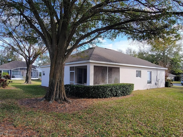 view of home's exterior featuring a sunroom and a lawn