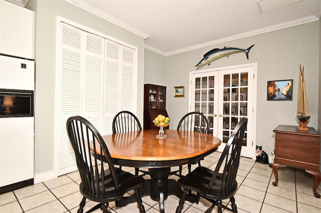 dining room featuring ornamental molding, light tile patterned flooring, and french doors