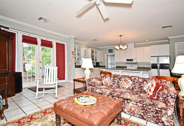 tiled living room with crown molding, ceiling fan with notable chandelier, and a textured ceiling