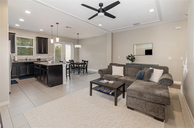 tiled living room featuring sink, a textured ceiling, and ceiling fan