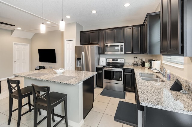 kitchen with stainless steel appliances, a center island, sink, and light tile patterned floors