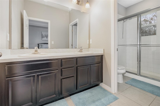 bathroom featuring tile patterned flooring, vanity, a shower with shower door, and toilet