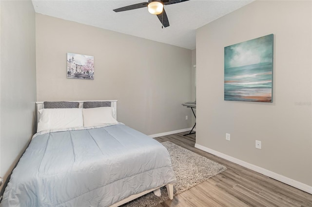 bedroom featuring a textured ceiling, wood-type flooring, and ceiling fan