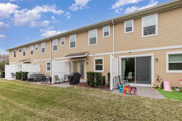 back of property with a patio, a yard, and cooling unit