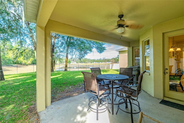 view of patio / terrace with ceiling fan, fence, and outdoor dining area