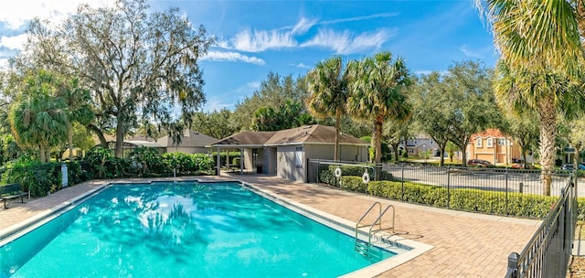 pool with a residential view, fence, and a patio