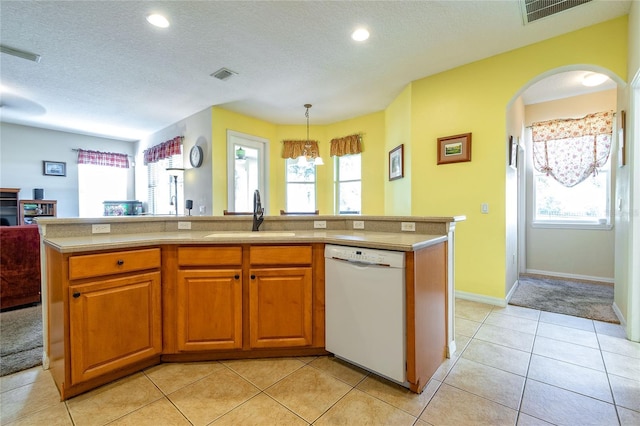 kitchen with white dishwasher, visible vents, and a sink