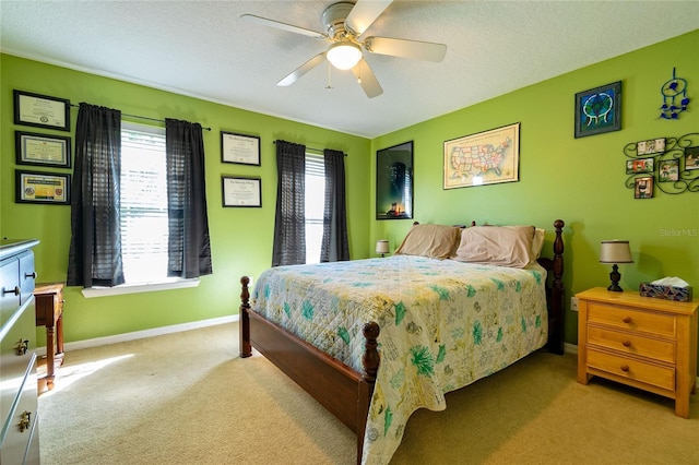 carpeted bedroom featuring a textured ceiling, a ceiling fan, and baseboards