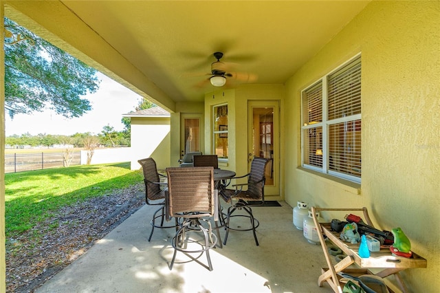 view of patio / terrace with fence, outdoor dining area, and a ceiling fan