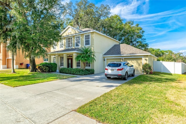 view of front of house with stucco siding, an attached garage, a front yard, a gate, and fence