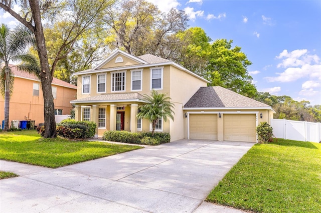 traditional-style house with a front yard, a garage, driveway, and stucco siding