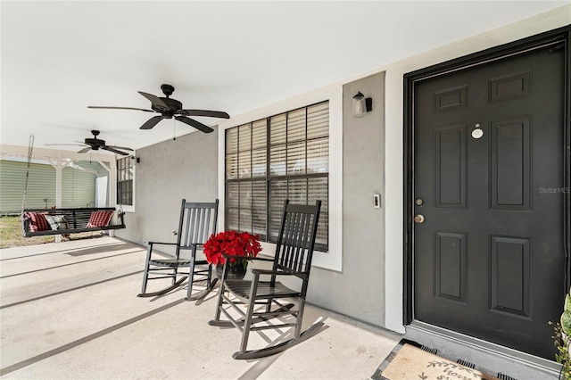 view of exterior entry featuring ceiling fan and covered porch