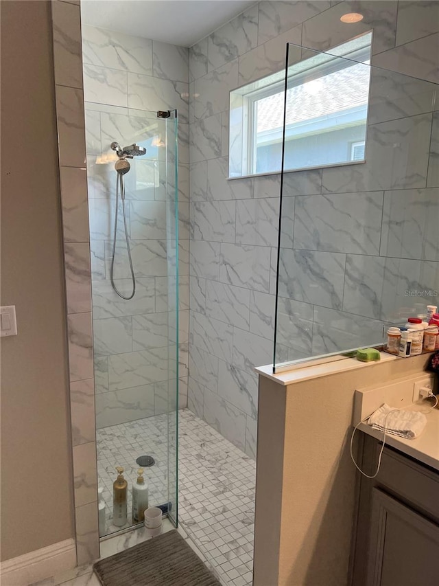 bathroom featuring a tile shower and vanity