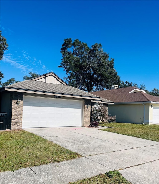 single story home featuring a garage and a front yard