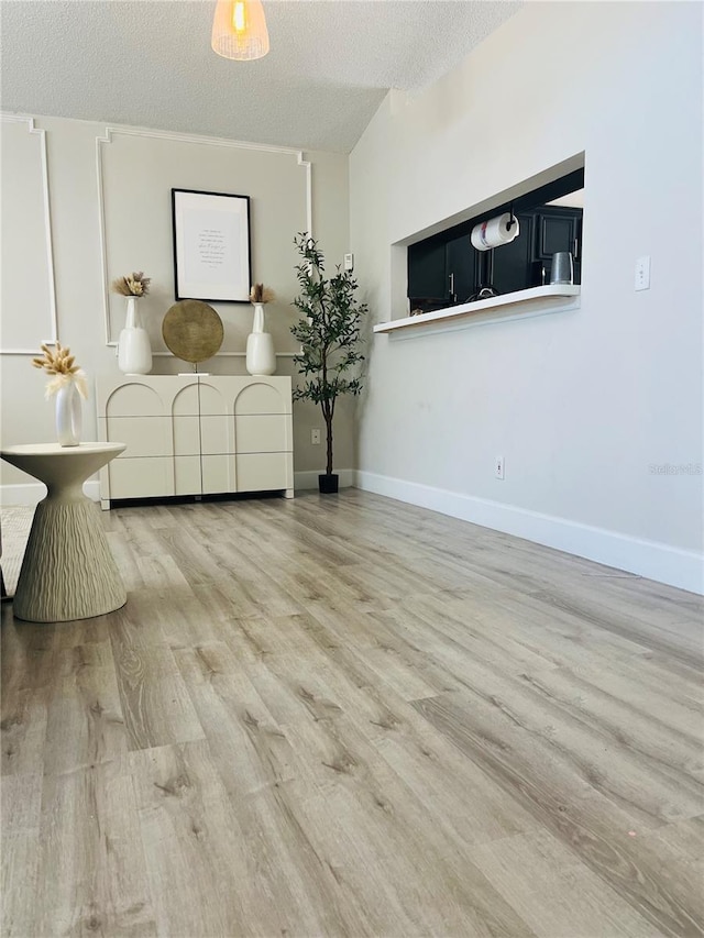 living room featuring a textured ceiling and light hardwood / wood-style flooring