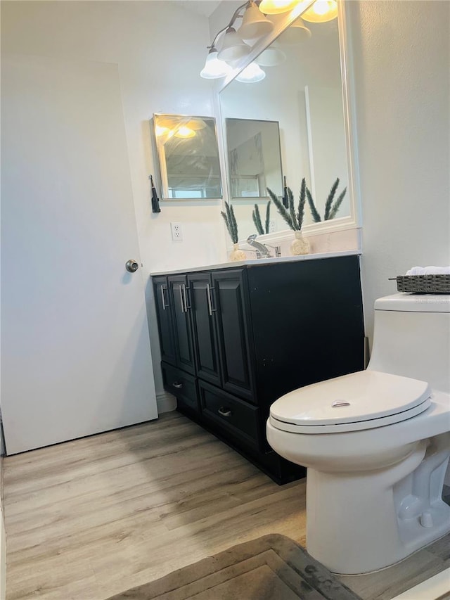 bathroom with vanity, hardwood / wood-style floors, and toilet