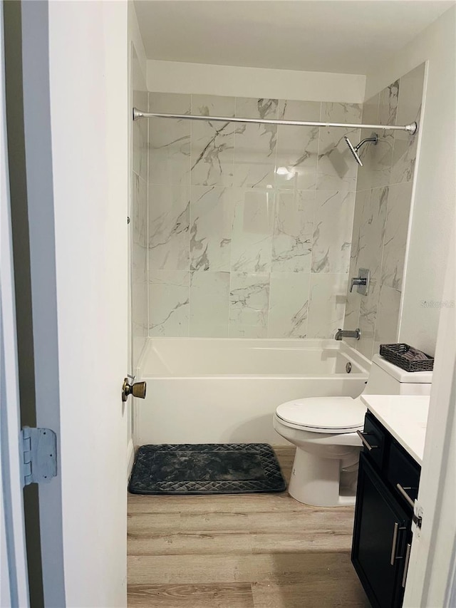 full bathroom featuring wood-type flooring, toilet, vanity, and tiled shower / bath