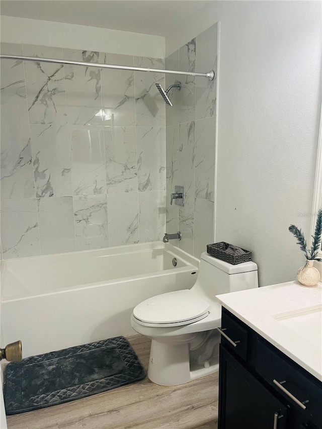 full bathroom featuring vanity, toilet, hardwood / wood-style floors, and tiled shower / bath