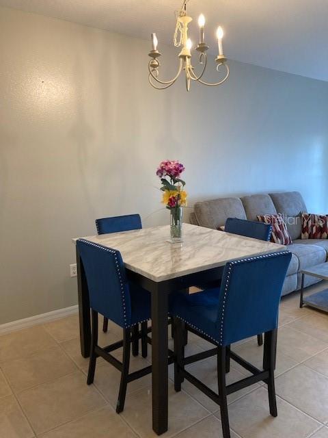 tiled dining space with a chandelier