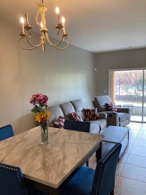 tiled dining area featuring a chandelier