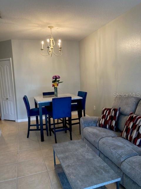 tiled dining space featuring a chandelier