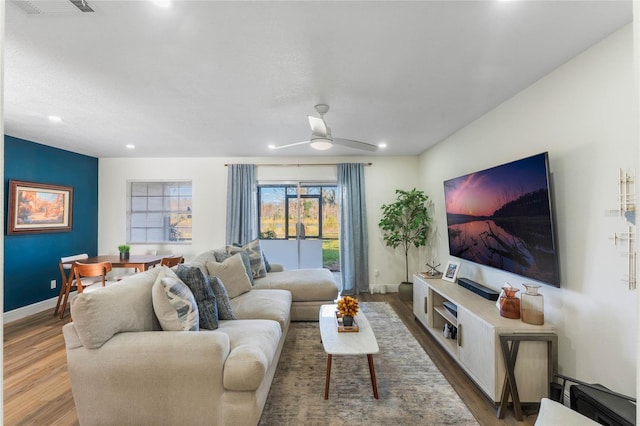 living room featuring ceiling fan and hardwood / wood-style floors