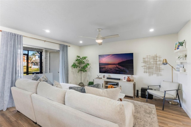 living room with wood-type flooring and ceiling fan