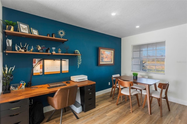 office area with light hardwood / wood-style flooring and a textured ceiling