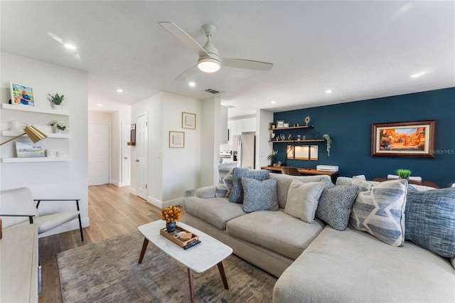 living room featuring hardwood / wood-style flooring and ceiling fan