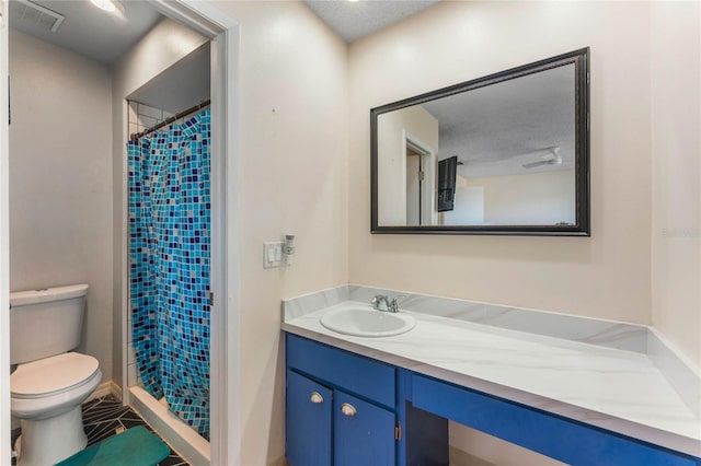 bathroom with vanity, curtained shower, a textured ceiling, and toilet