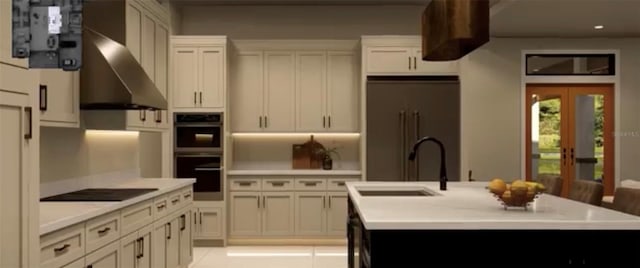 kitchen featuring wall chimney range hood, sink, a kitchen island with sink, black appliances, and light tile patterned flooring