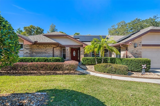 view of front of house featuring a garage, a front yard, and solar panels