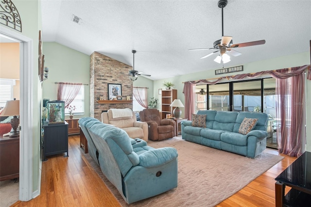 living room featuring hardwood / wood-style flooring, ceiling fan, plenty of natural light, and vaulted ceiling