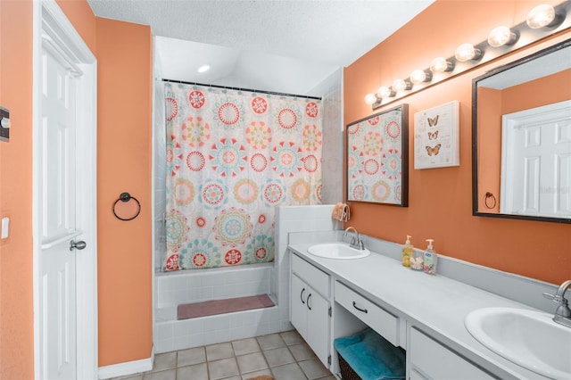 bathroom with vanity, tile patterned floors, shower / bath combination with curtain, and a textured ceiling