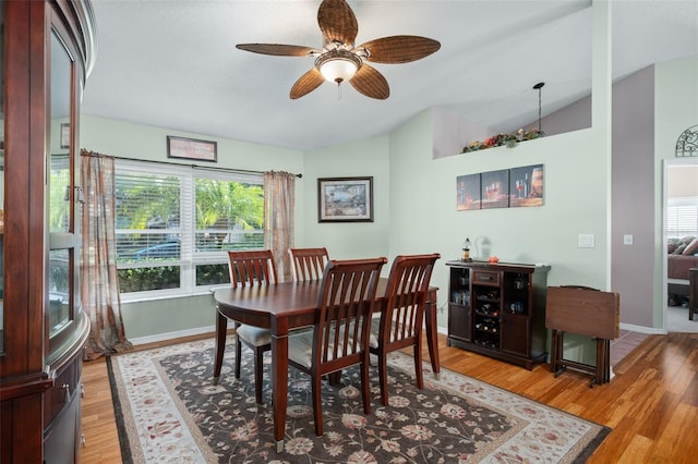 dining room with ceiling fan, lofted ceiling, and light hardwood / wood-style floors