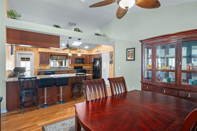 dining area with lofted ceiling, sink, ceiling fan, and light hardwood / wood-style flooring