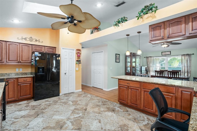 kitchen featuring ceiling fan, decorative light fixtures, black fridge with ice dispenser, and light stone countertops