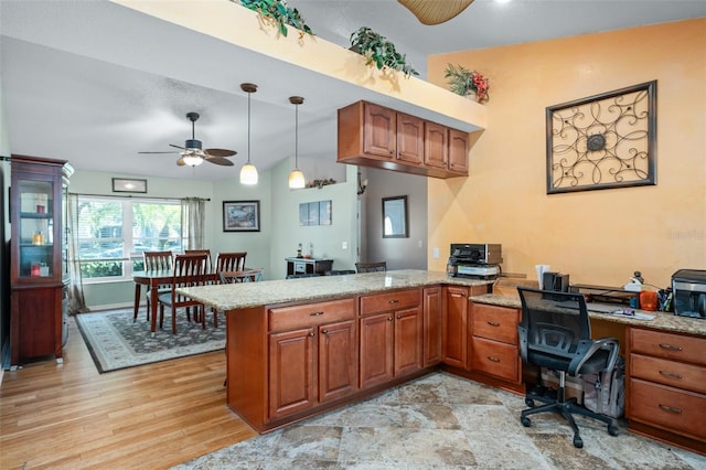 kitchen featuring pendant lighting, lofted ceiling, ceiling fan, kitchen peninsula, and light wood-type flooring