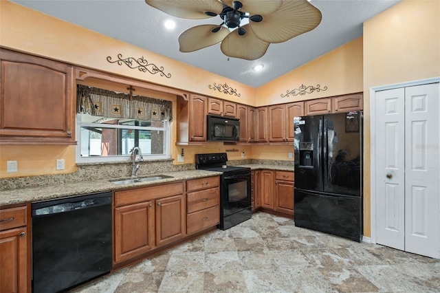 kitchen with lofted ceiling, sink, ceiling fan, light stone counters, and black appliances