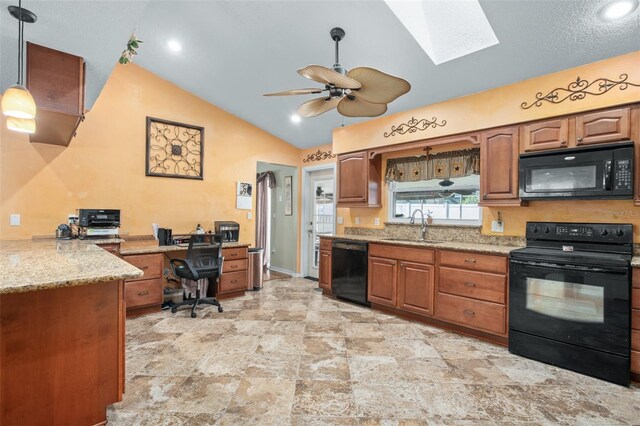 kitchen featuring vaulted ceiling with skylight, decorative light fixtures, sink, light stone counters, and black appliances