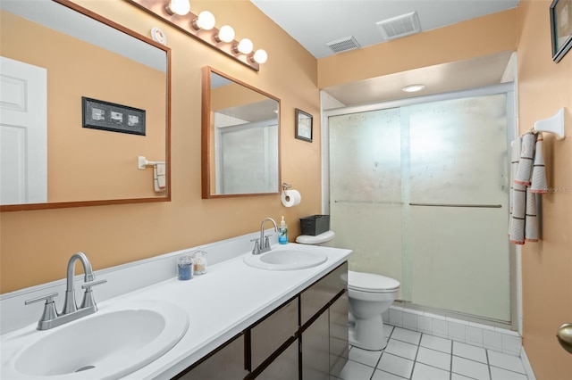 bathroom featuring tile patterned flooring, an enclosed shower, vanity, and toilet