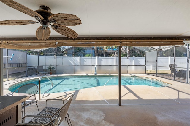 view of pool with glass enclosure, ceiling fan, and a patio area