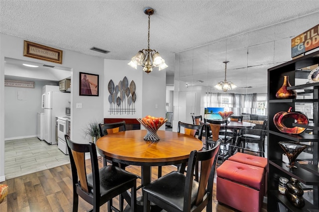 dining space with a textured ceiling and a chandelier